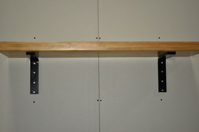 two surface mounted flat brackets supporting a shelf