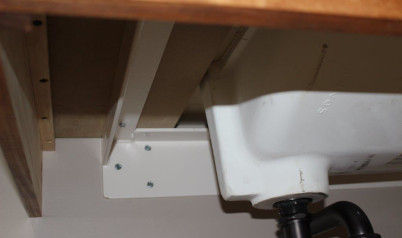 A closeup shot from below of the underside of the floating vanity where the sink is inlaid